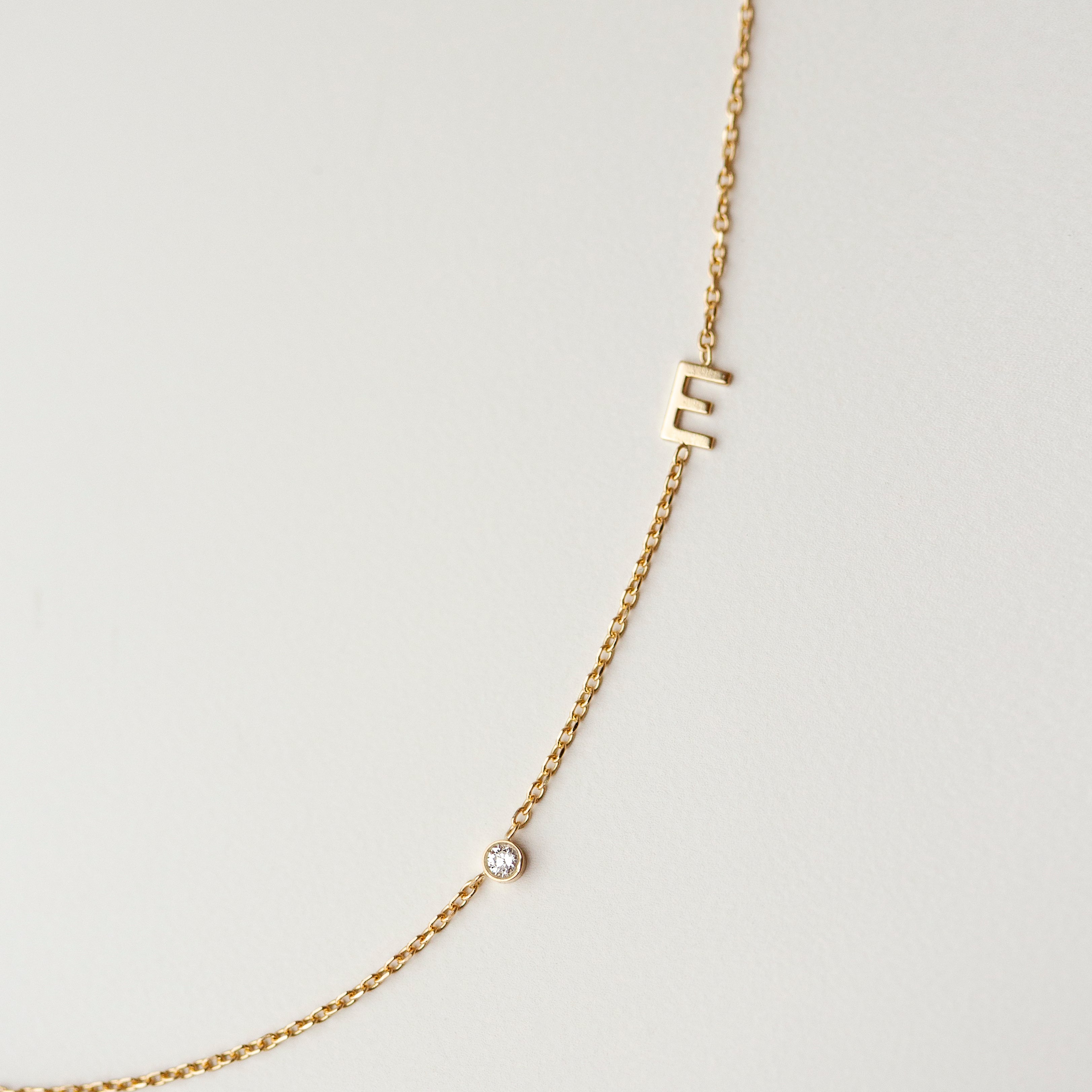 Personalized Asymmetrical 14k solid gold initials necklace with small diamond bezel.