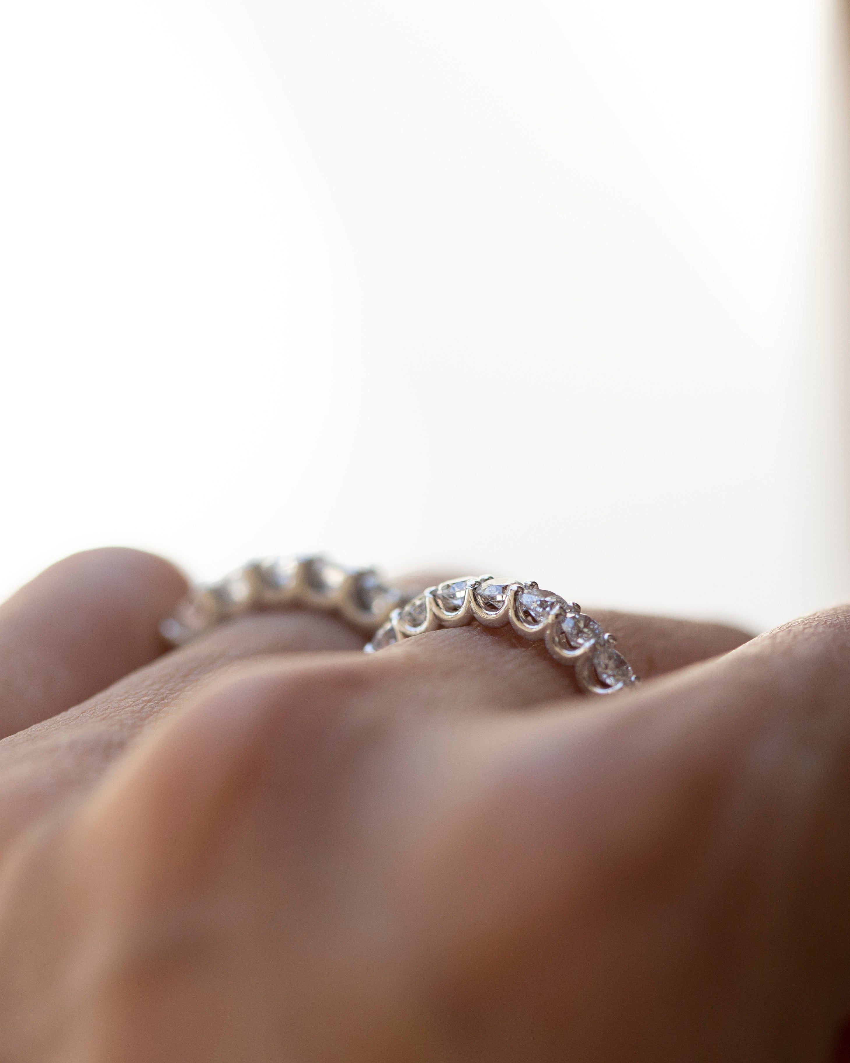 Diamond ring on a finger with a blurred background
