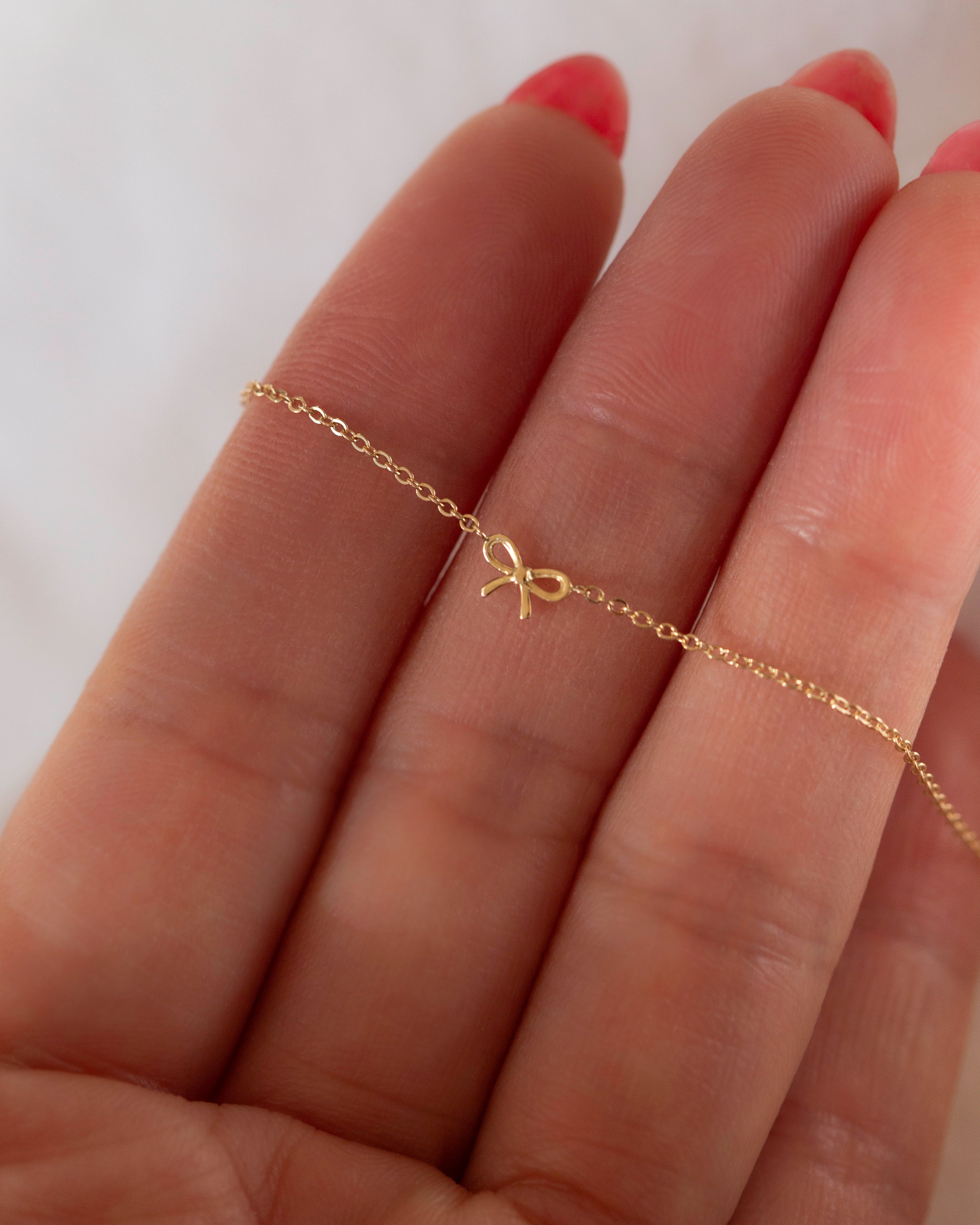 This 14k gold bracelet features a delicate bow, making it ideal for everyday wear. Its petite design is perfect for making a subtle statement.