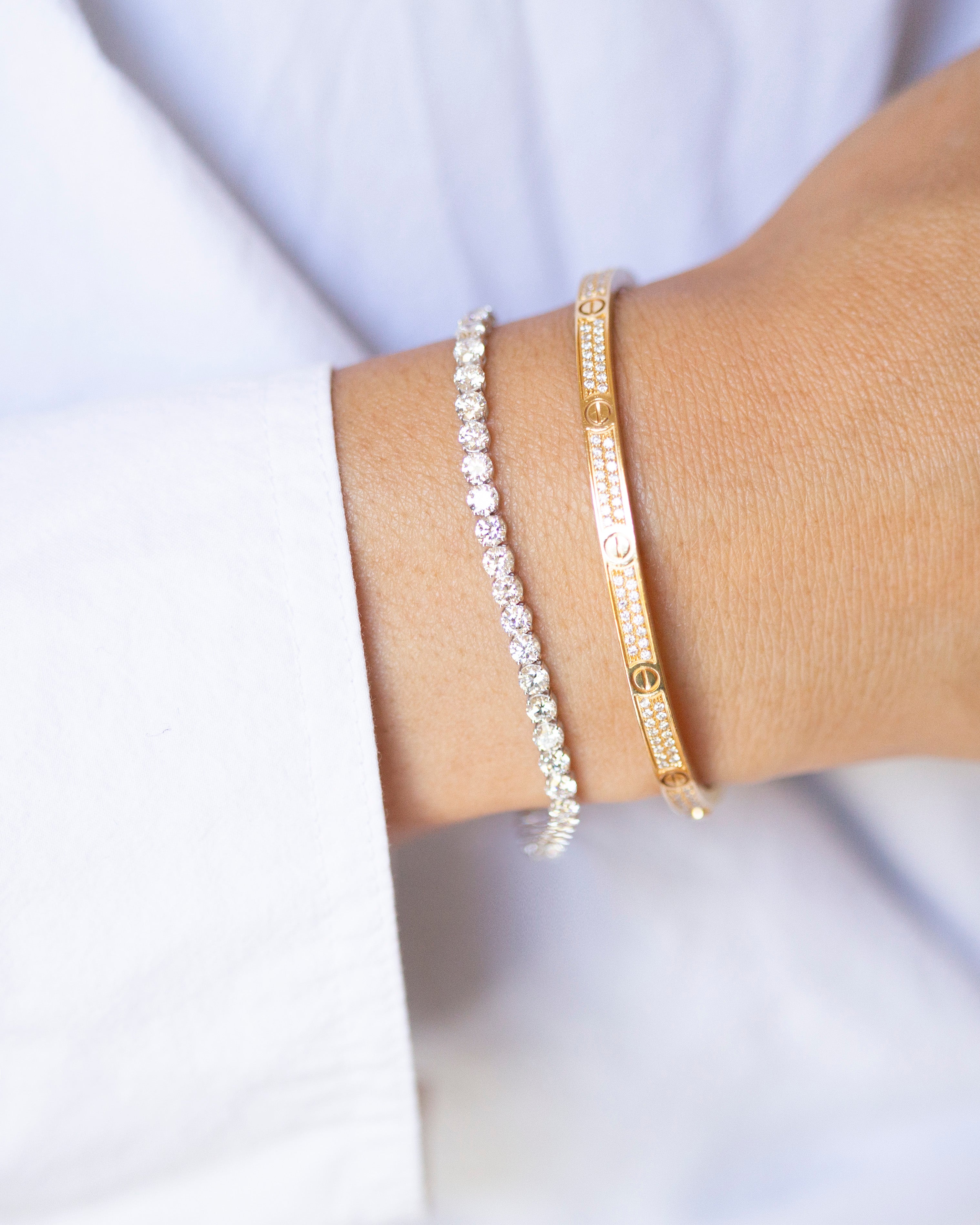 Two bracelets on a wrist against a light background