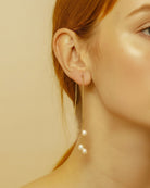 Pearl earring worn by a person with a plain background
