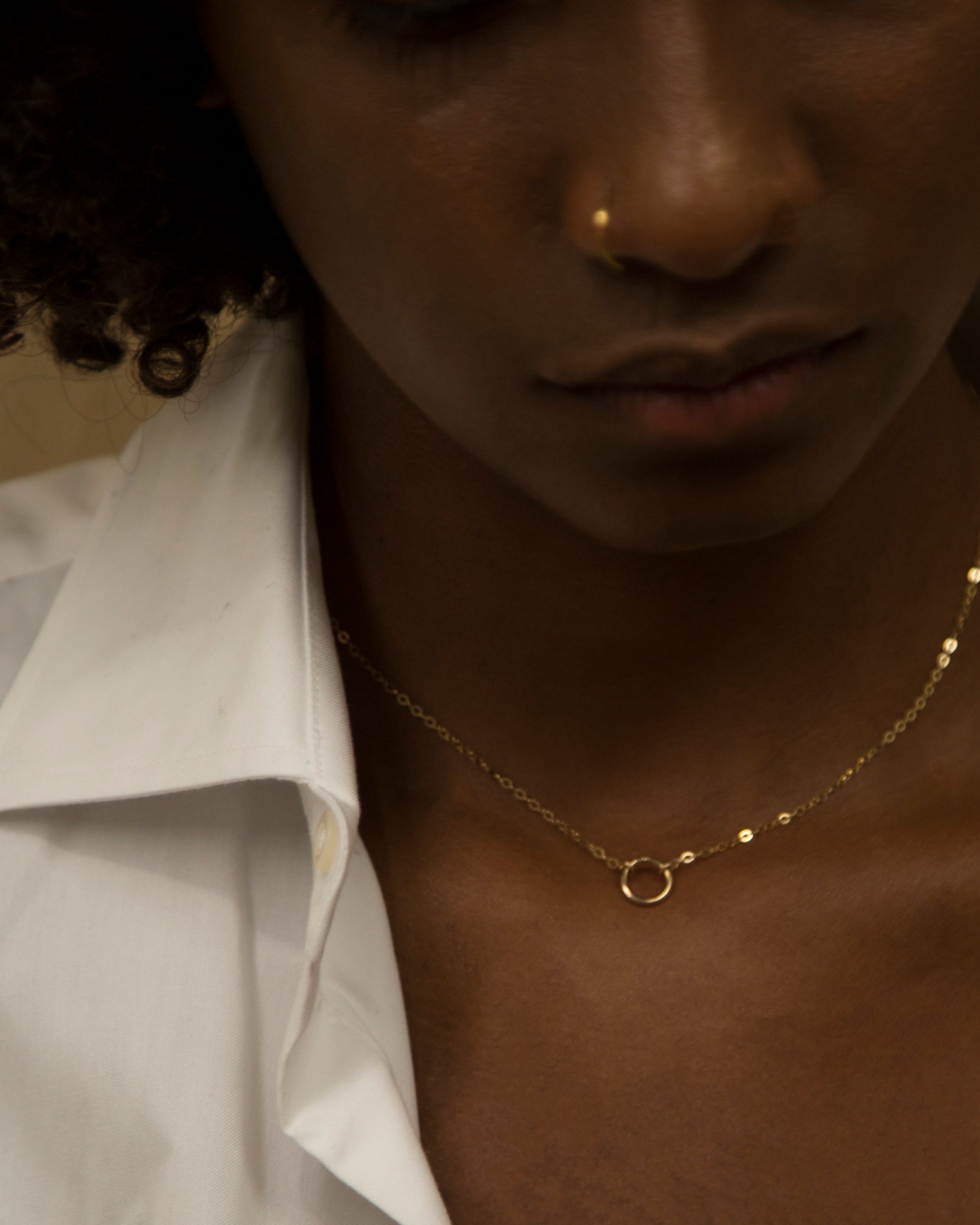 This exquisitely crafted 14K gold halo circle charm necklace exudes a sense of simplicity and elegance, making it the perfect addition to your everyday wardrobe.