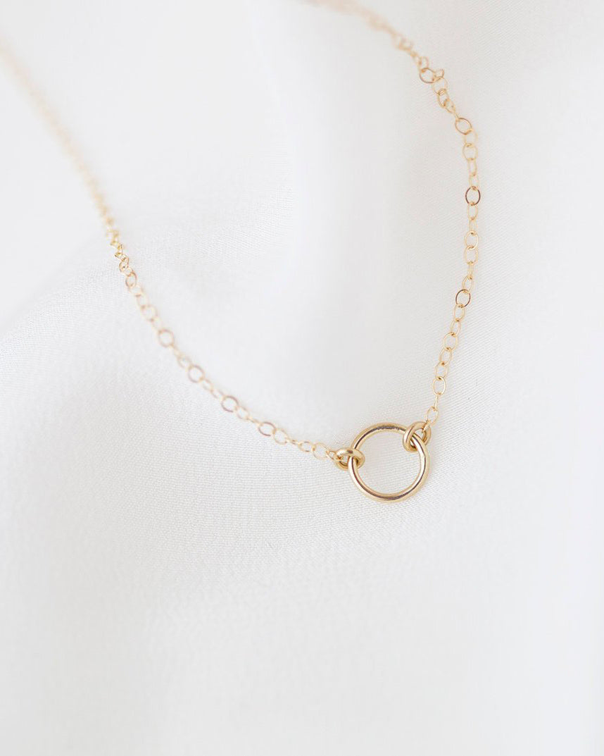 This exquisitely crafted 14K gold halo circle charm necklace exudes a sense of simplicity and elegance, making it the perfect addition to your everyday wardrobe.