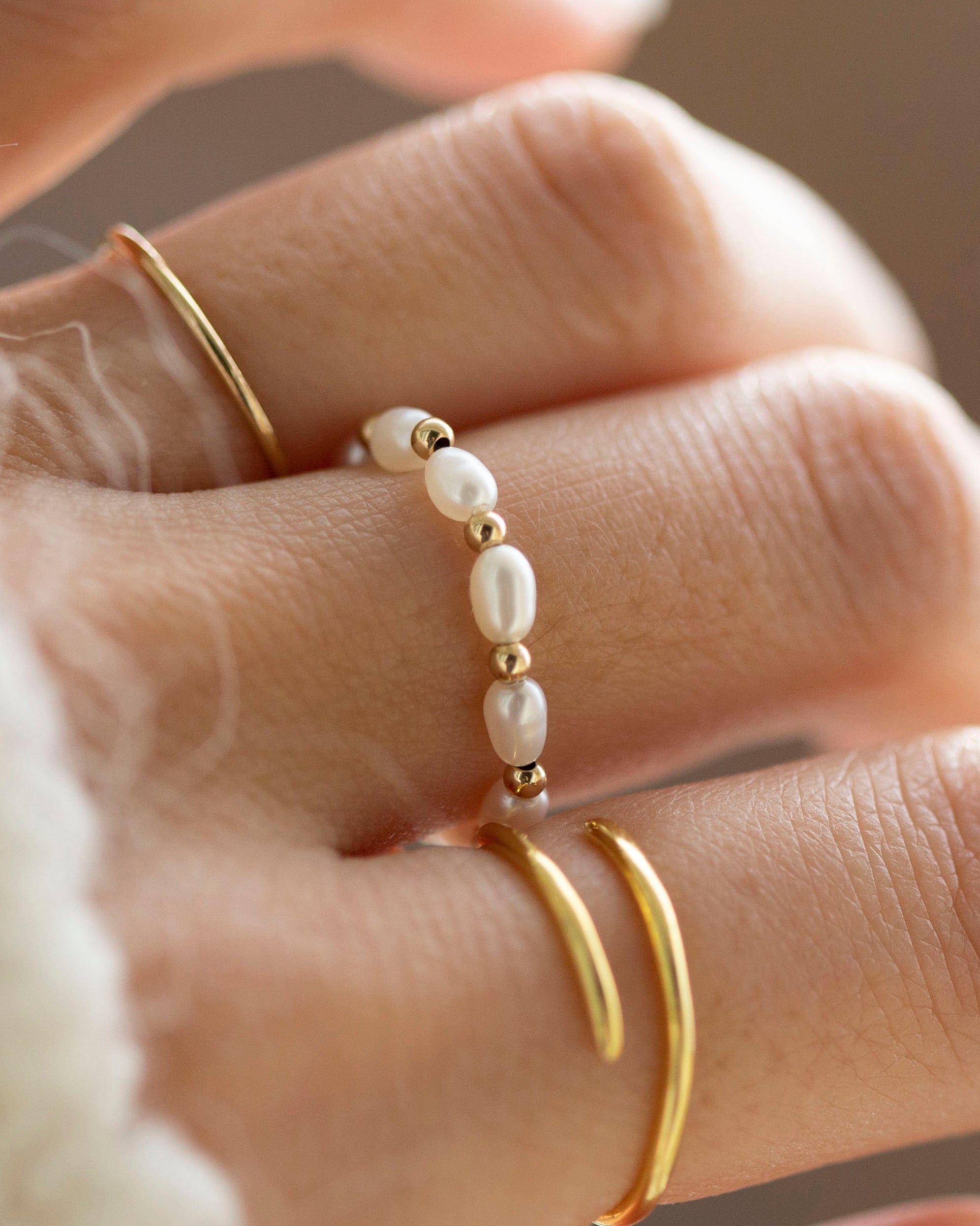 Baby Lotus Pearl Ring with Baby Beads

Made with mini rice shape fresh water pearls and mini gold filled bead on a
comfy stretchy elastic band. Baby lotus pearl ring will be the perfect addition to your ring stack!