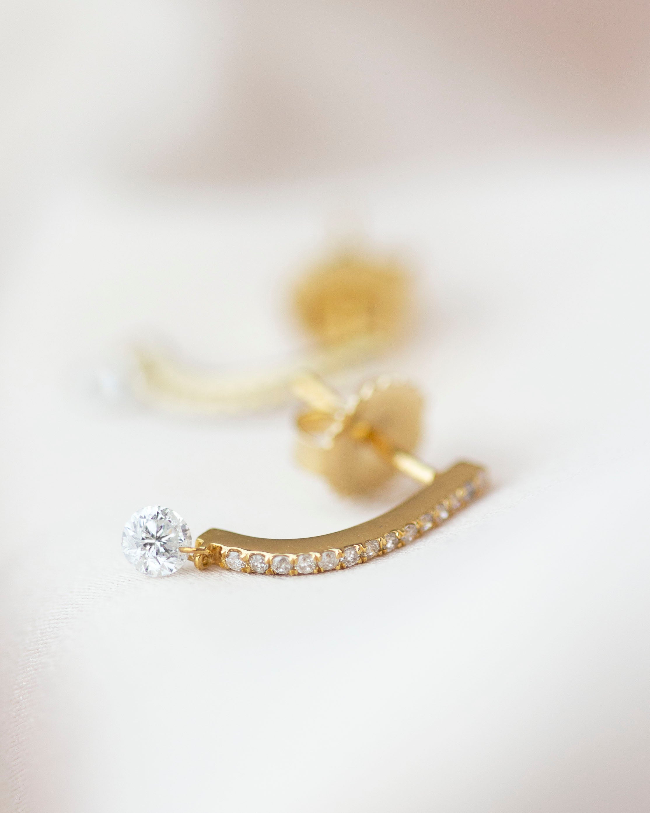 These 14k J-hoop earrings feature a dazzling diamond solitaire drop, adding extra sparkle. They are versatile enough to be worn as an everyday earring or as a statement piece.