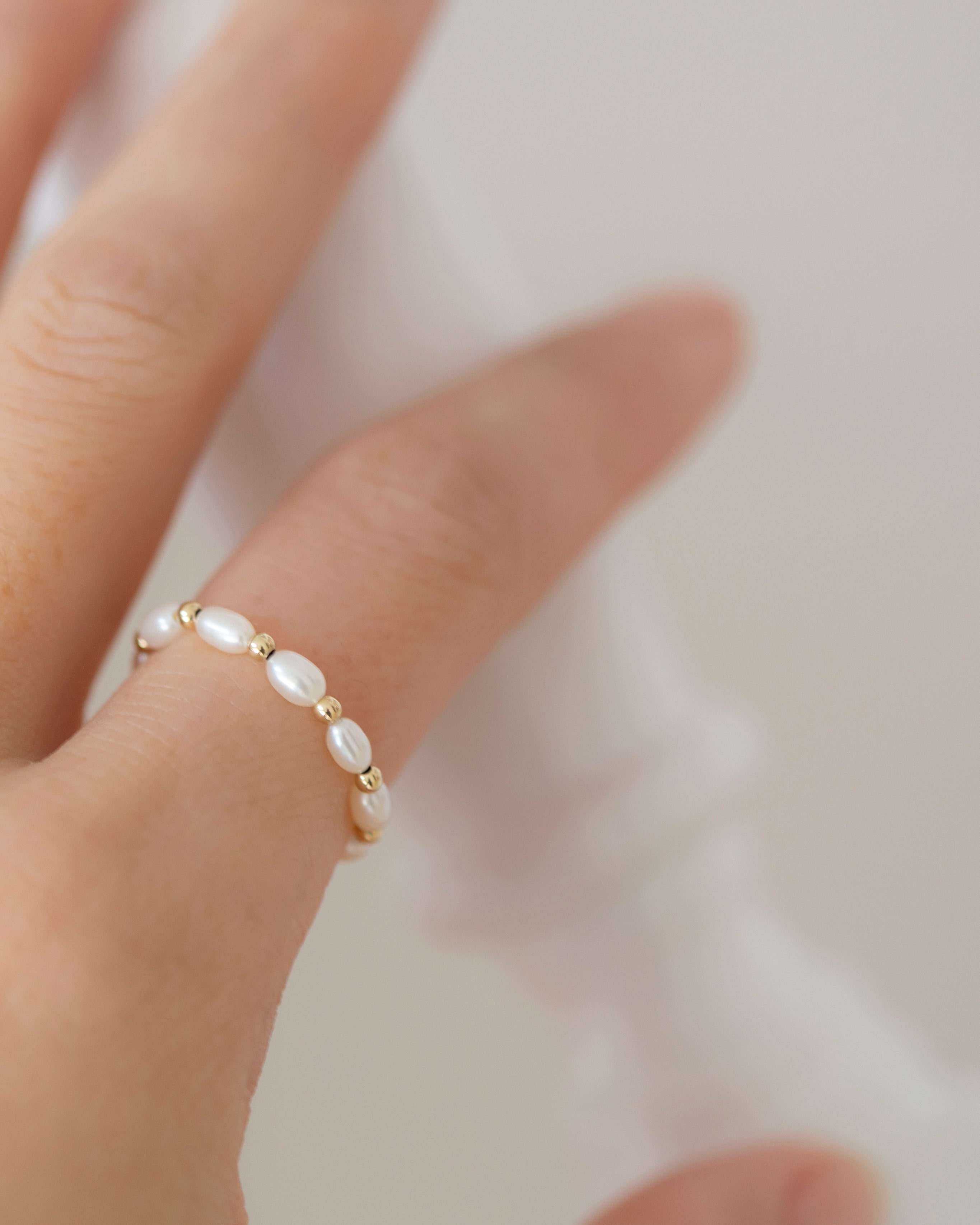 Baby Lotus Pearl Ring with Baby Beads

Made with mini rice shape fresh water pearls and mini gold filled bead on a
comfy stretchy elastic band. Baby lotus pearl ring will be the perfect addition to your ring stack!