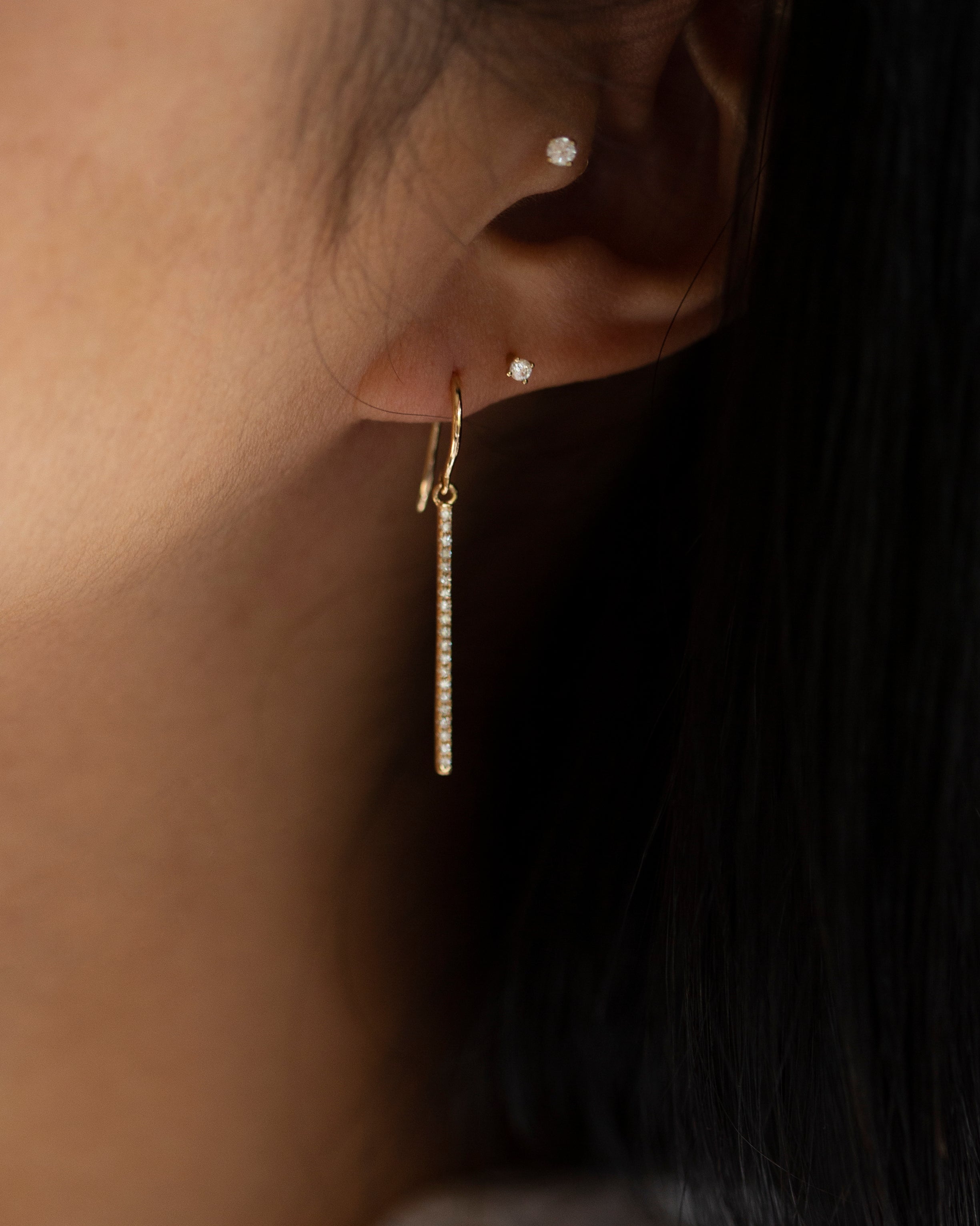 These exquisite 14k gold drop bar earrings feature genuine diamonds, adding a modern touch to their versatile design. A must-have for those seeking a timeless and sophisticated accessory.