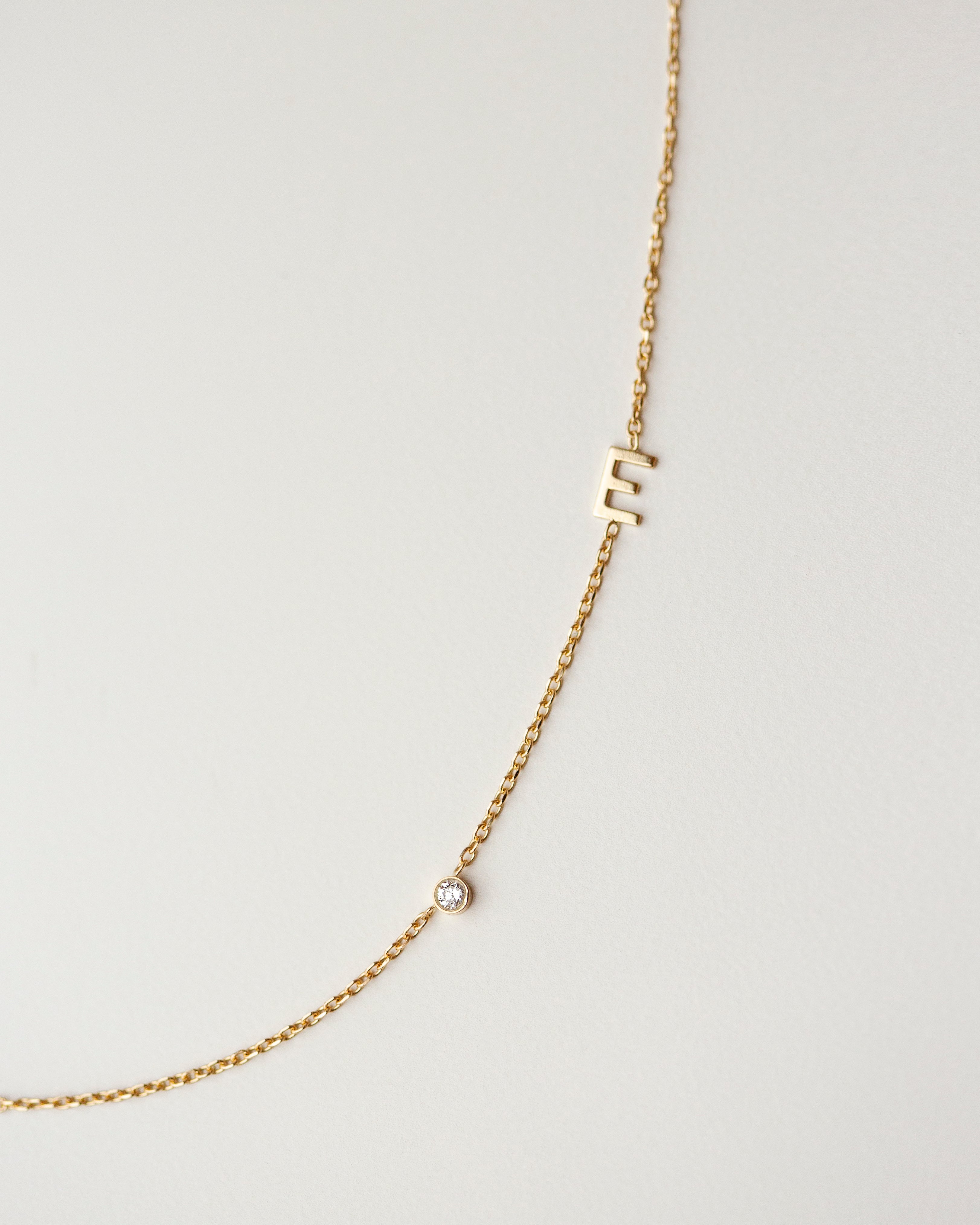 Personalized Asymmetrical 14k solid gold initials necklace with small diamond bezel.