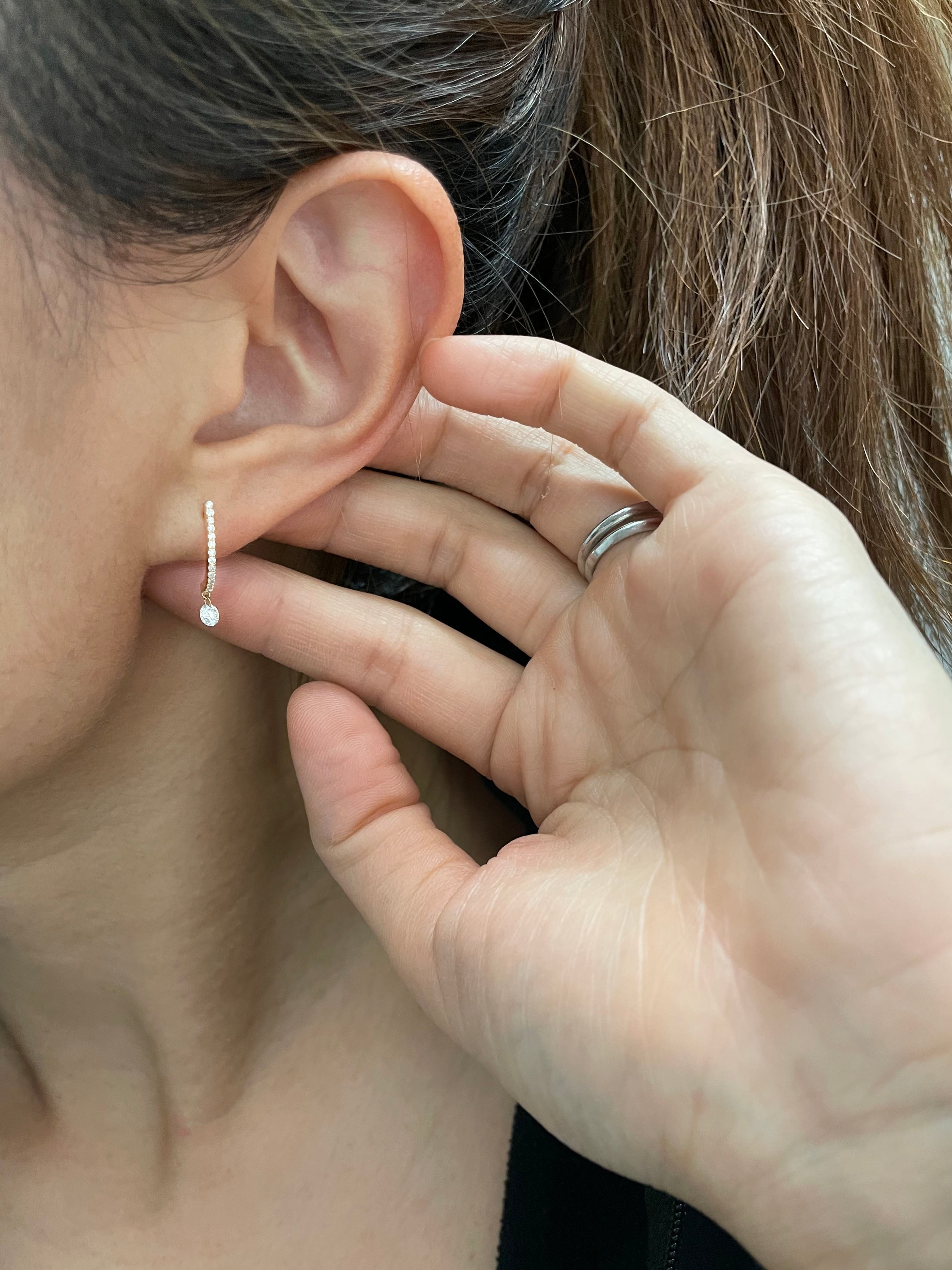 These 14k J-hoop earrings feature a dazzling diamond solitaire drop, adding extra sparkle. They are versatile enough to be worn as an everyday earring or as a statement piece.