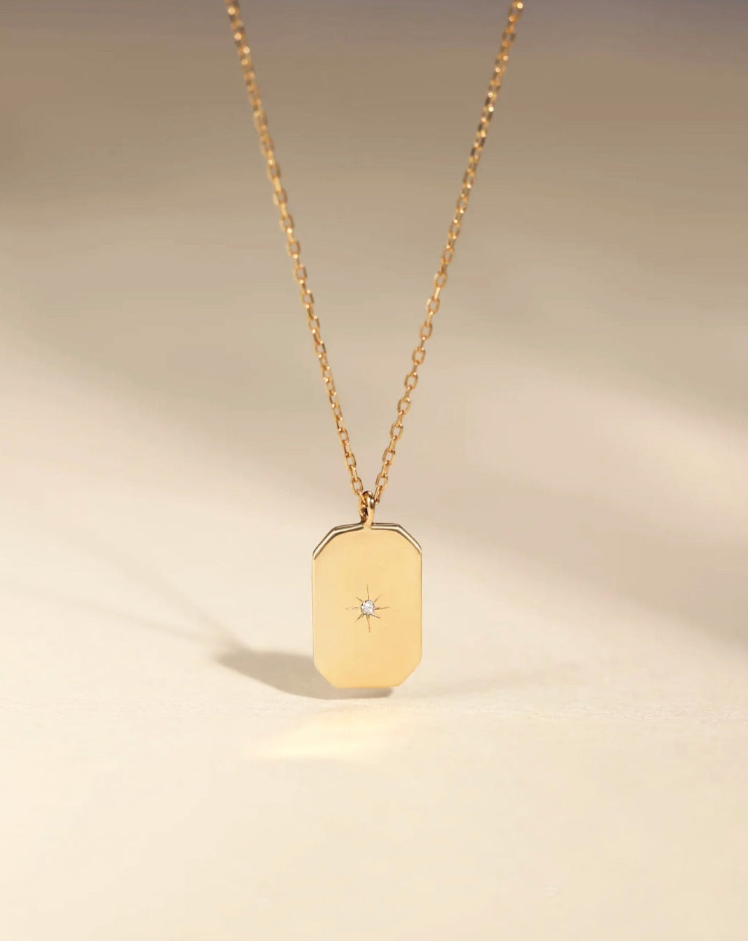 This 14k Gold Mini Diamond Tag Necklace is minimalistic and simple, yet adds a special touch with its small diamond star tag. It provides the perfect everyday accessory when worn alone or layered with other necklaces.
