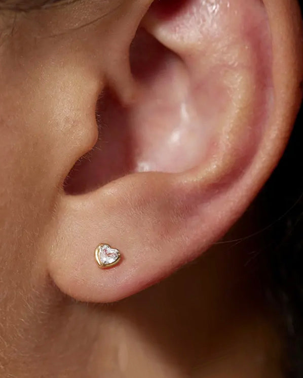 This 14k Heart White Topaz Stud Earring offers unique minimalism and superior craftsmanship for a timeless look. It has a screw flat back for extra security and comfort.

Minimalist, high quality, and timeless.
Very secure and comfortable to wear.